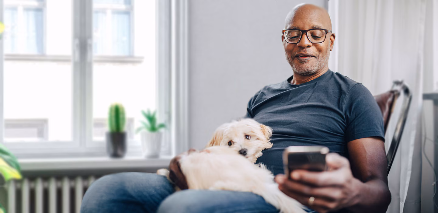 Person relaxing with pet while using phone